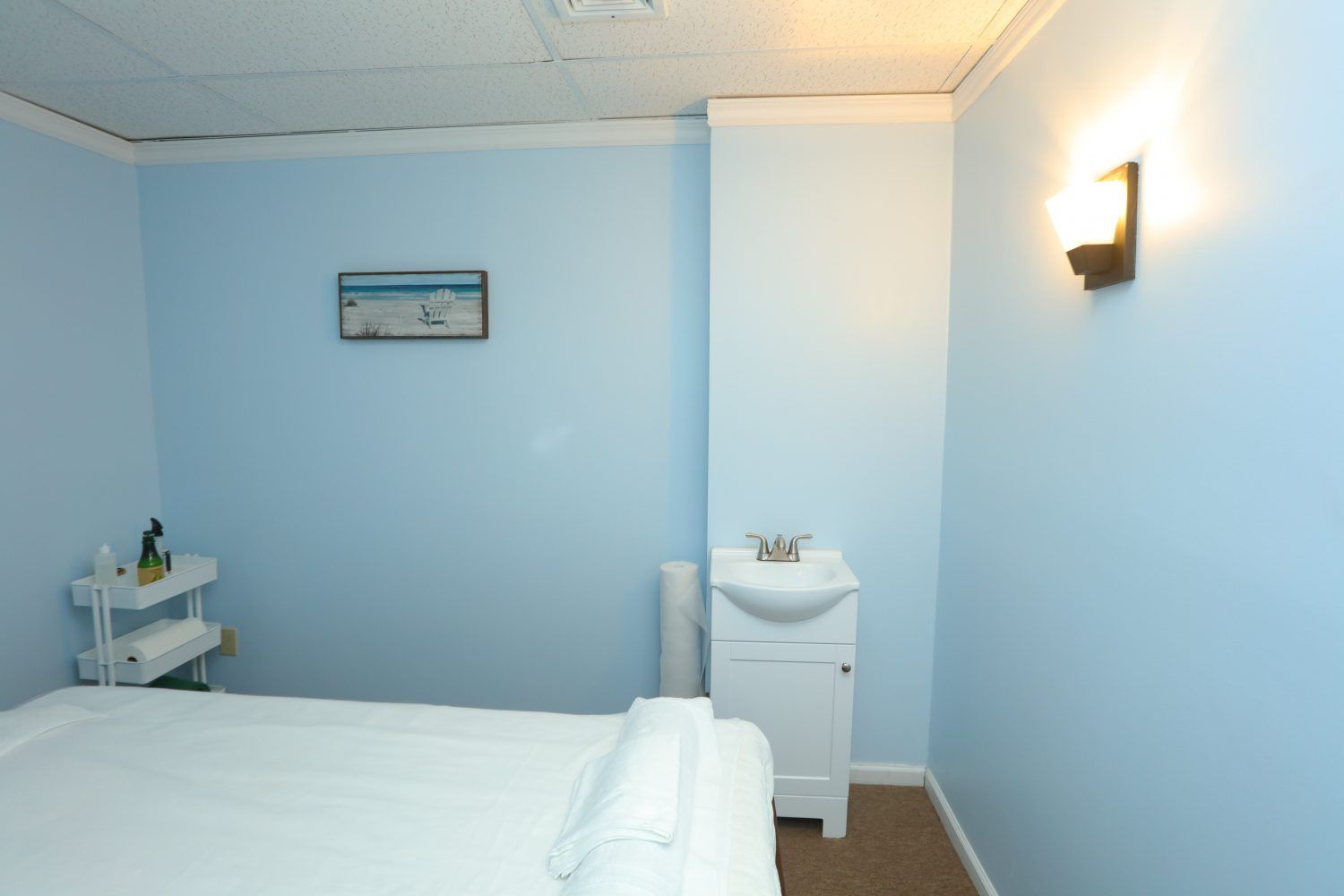 Private massage room featuring soft blue walls and a clean setup